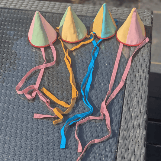 Colorful kite hats with ribbons on a textured surface